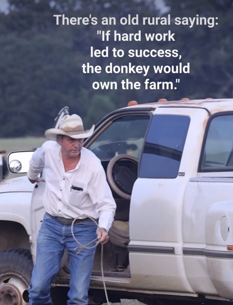 A man wearing a cowboy hat, a white long-sleeved shirt, and blue jeans is stepping out of a white pickup truck. He is holding a coiled rope in his hand. The background shows a blurry rural landscape with trees. Overlaid on the image is white text containing a quote.