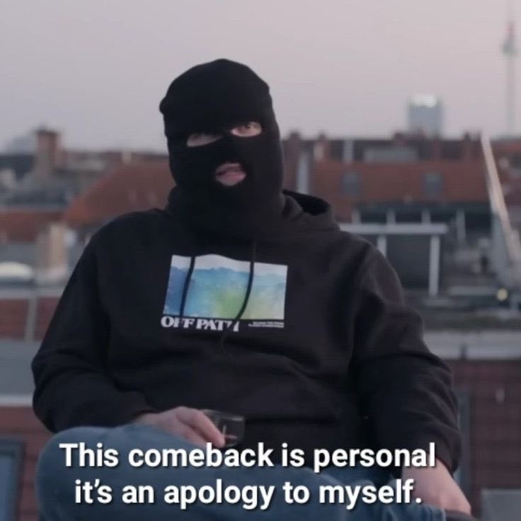 A person wearing a black balaclava and a black hoodie with a graphic print that says 'OFF PAT' is sitting outdoors against a blurred city background. There is a text overlay at the bottom of the image.