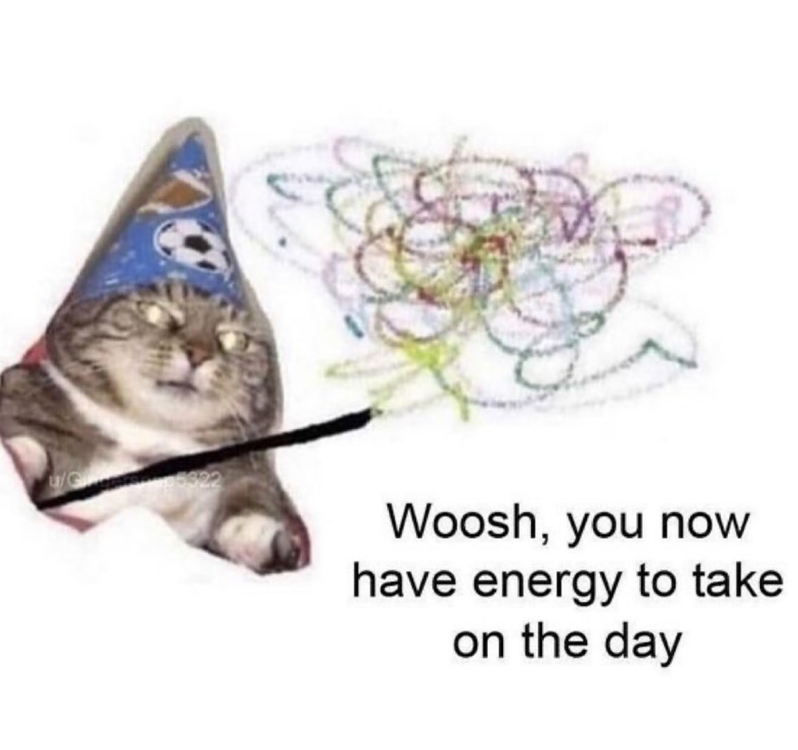 A humorous meme featuring a wide-eyed, somewhat disheveled tabby cat wearing a blue party hat with a soccer ball pattern. The cat is holding a magic wand that is emitting a colorful, scribbled burst of energy. The background is plain white. Text at the bottom reads: 'Woosh, you now have energy to take on the day'.