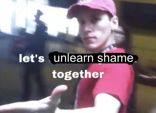 A low-resolution, slightly blurry meme image featuring a young man wearing a pink baseball cap and a red shirt. He is looking towards the camera with a neutral expression, gesturing with one hand extended towards the viewer. The background is dark and out of focus. White text is overlaid on the image.