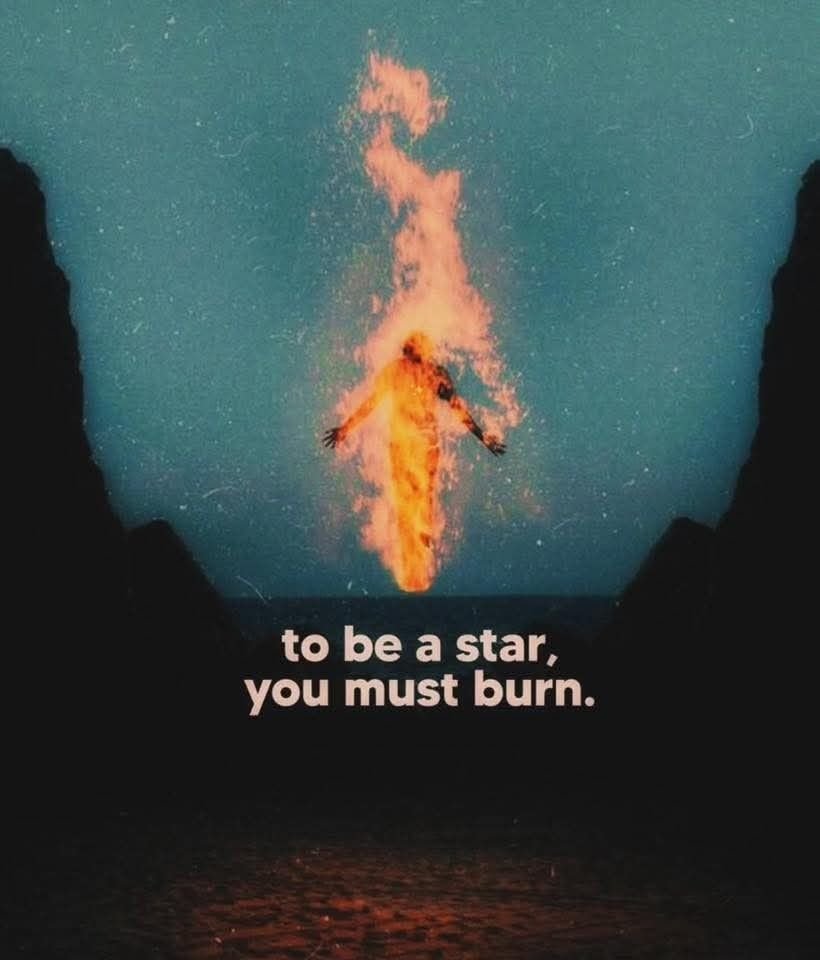 A surreal, artistic image featuring a human figure made of bright orange and yellow flames, appearing to rise or float upwards towards the sky. The figure is centered between two dark, silhouetted landmasses or cliffs, creating a frame. The background is a deep teal or dark blue sky with a grainy, starry texture. At the bottom of the image, there is text in a white, serif font that reads 'to be a star, you must burn.'