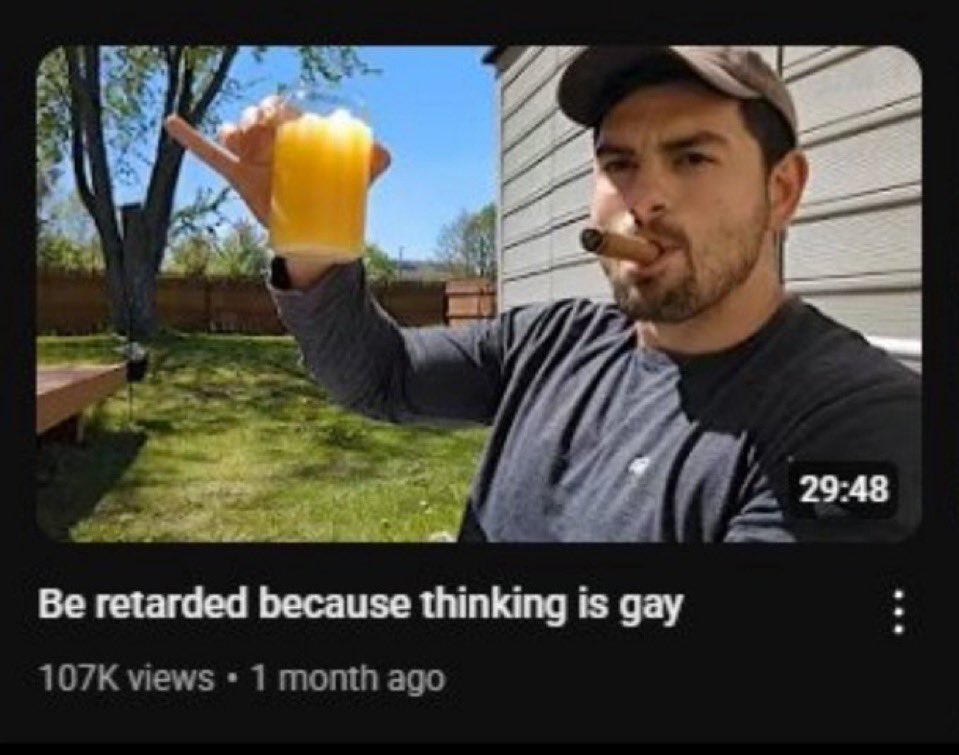 A screenshot of a YouTube video thumbnail and title. The thumbnail features a man wearing a baseball cap and a black long-sleeve shirt, holding a glass of orange juice in one hand and a cigar in his mouth. He is outdoors in a backyard setting with grass and trees. The video title below the thumbnail contains a slur and a provocative statement. The video shows 107K views and was posted 1 month ago, with a duration of 29:48.