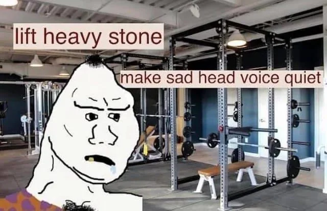 A meme featuring the 'Forever Alone' rage comic character against a background of a gym with weightlifting equipment. The text at the top reads 'lift heavy stone' and the text in the middle reads 'make sad head voice quiet'.